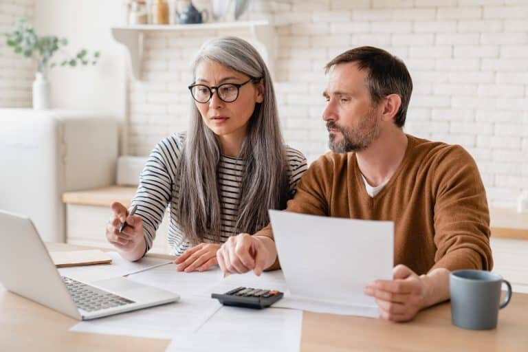 Mature middle-aged couple family wife and husband counting funds savings declarations investments